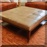 F05. Michael Weiss square leather ottoman on casters. 17”h x 43”w x 43”d 